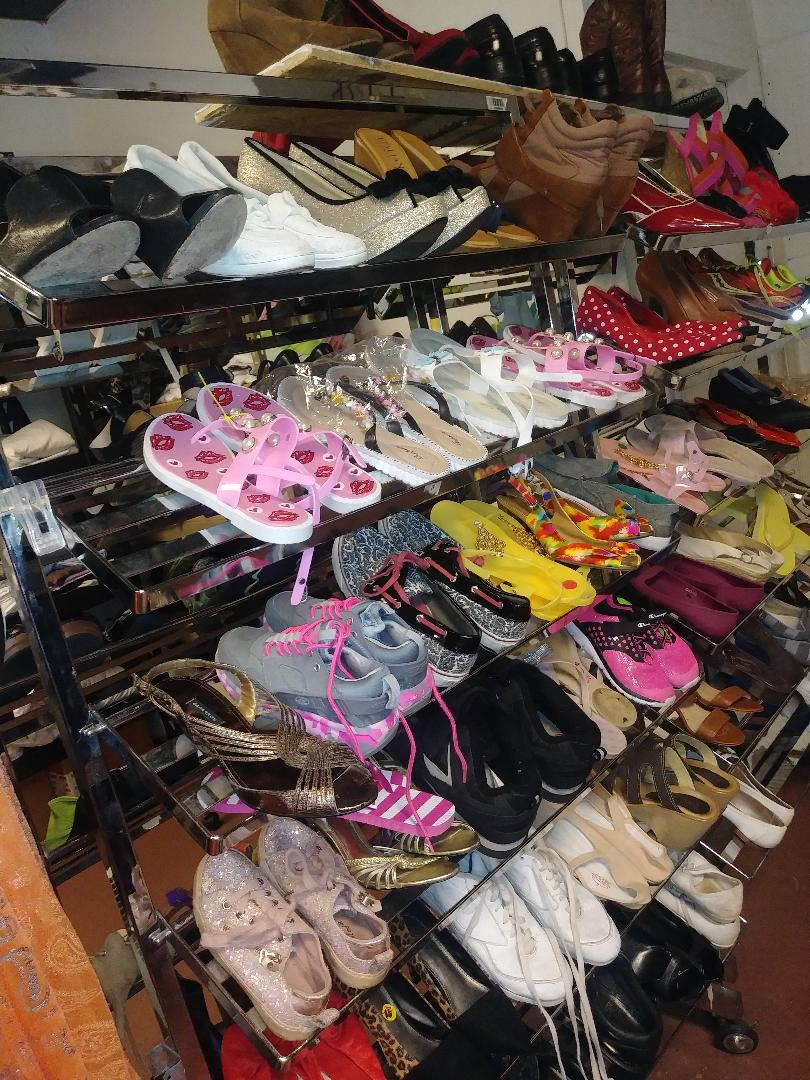 A large amount of shoes are stacked on top of each other.